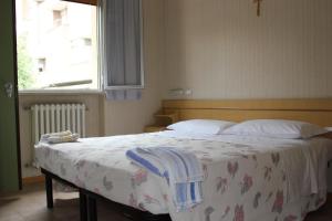 ein Schlafzimmer mit einem Bett mit einer Decke und einem Fenster in der Unterkunft Hotel Pierina in Castrocaro Terme