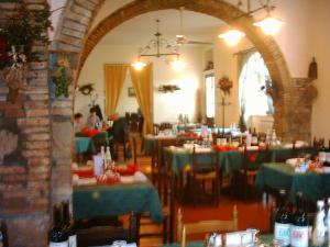 a dining room with tables with green table settings at Hotel Il Malandrone in Rosignano Marittimo