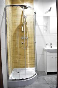y baño con ducha y puerta de cristal. en Studio Fibra Dolce en Rybnik