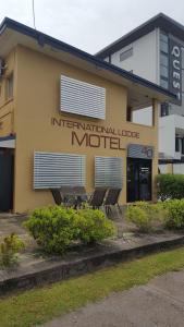 un edificio con sillas frente a un motel en International Lodge Motel, en Mackay