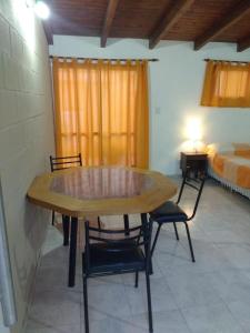 mesa y sillas en una habitación con cama en Complejo Nuestros Hijos en Villa Carlos Paz