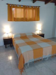 1 dormitorio con 1 cama con 2 mesas y 2 lámparas en Complejo Nuestros Hijos en Villa Carlos Paz
