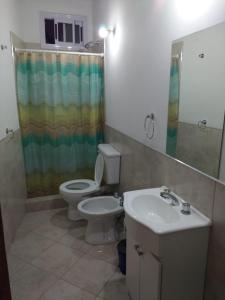 y baño con aseo, lavabo y ducha. en Complejo Nuestros Hijos en Villa Carlos Paz