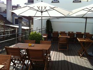 a patio with tables and chairs and umbrellas at Hotel Hirschen in Zürich