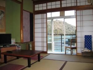 a living room with a table and a large window at Ryokan Nakaya in Hamamatsu