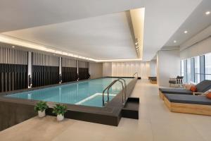 a swimming pool in a hotel room with a couch and a table at Hyatt Place Shanghai Tianshan Plaza in Shanghai
