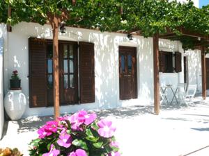 a white building with purple flowers in front of it at Ariston Apartments in Serifos Chora