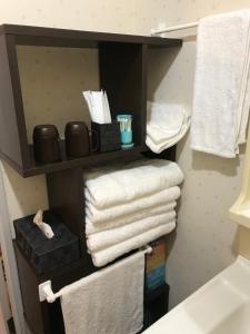 a bathroom with towels on a shelf at Lipelala Stay 505 in Osaka