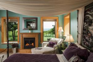 a room with a fireplace and a bed and a chair at INN AT WAWANISSEE POINT in Baraboo