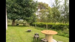 a table and chairs in a yard with a tree at The Caretakers Cottage in Main Ridge