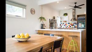 a kitchen with a wooden table with a bowl of fruit on it at The Caretakers Cottage in Main Ridge