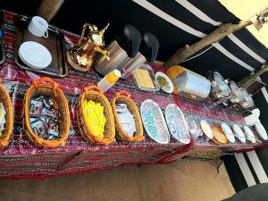 a table with baskets of food and utensils on it at Queen Desert camp in Fulayj al Mashāʼikh