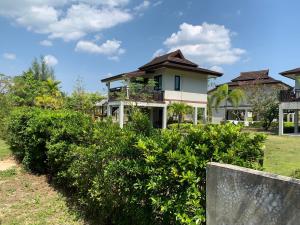 a house with bushes in front of it at The Hip Resort @ Khao Lak in Bang Sak