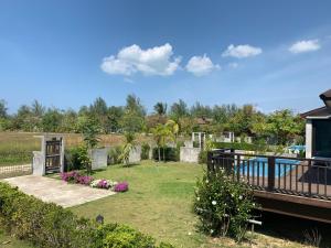 un patio trasero con un jardín y una casa en The Hip Resort @ Khao Lak, en Bang Sak