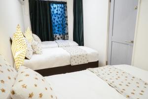 3 łóżka w pokoju z białą pościelą w obiekcie Blue Empire Hotel w Tokio
