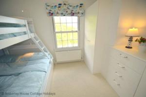 a bedroom with a bunk bed and a window at Tackleway Cottage in Hastings