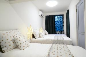 2 białe łóżka w pokoju z oknem w obiekcie Blue Empire Hotel w Tokio