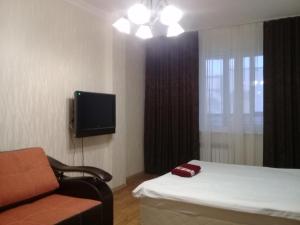 サレハルドにあるИЛНЕ Однокомнатная квартира на улице Мираのベッド、テレビ、椅子が備わる客室です。