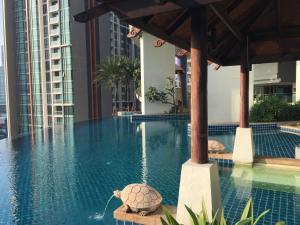 a turtle sitting on a bench in a swimming pool at OV Residence in Bangkok