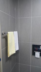 ein Bad mit Dusche und Handtüchern an der Wand in der Unterkunft Nadree House 2 in Sokcho