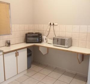a kitchen with a counter with a toaster oven and a microwave at Home Sweet Home in Keetmanshoop