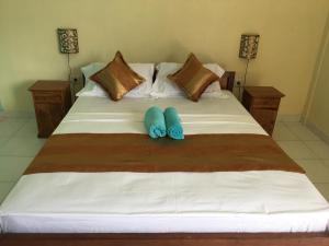 a large white bed with two blue pillows on it at Repag Wayan Canggu Hostel in Canggu