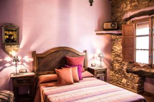 a bedroom with a bed and a stone wall at La Mallada in Sant Jordi