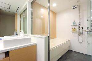 y baño con lavabo, ducha y bañera. en Hakata Tokyu REI Hotel, en Fukuoka