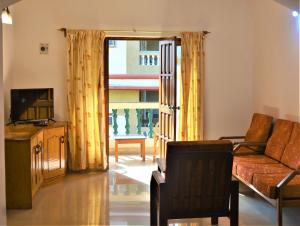 a living room with a couch and a television at Sonika's Paradise (Studio) in Candolim