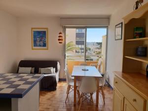una cucina e un soggiorno con tavolo e sedie di Gites de France Bleu à la mer a Port-la-Nouvelle