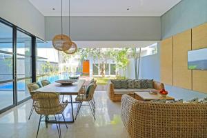a living room with a dining table and chairs at Origin Seminyak in Seminyak