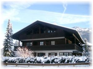 un gran edificio con nieve en el suelo en Haus Mariandl, en Unterwossen