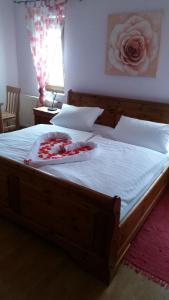 a bedroom with a large wooden bed with white sheets at Gasthof zur Alten Post-Pension in Fürstenzell