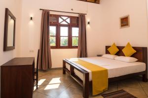 a bedroom with a bed and a window at Villa Manali in Hikkaduwa