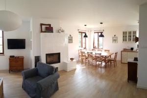 a living room with a fireplace and a table and chairs at Wyskok 1 - dom z widokiem in Srokowo