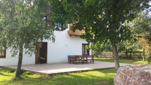 a white house with a picnic table in the yard at Wyskok 1 - dom z widokiem in Srokowo