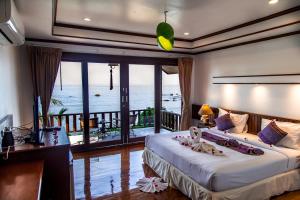 a bedroom with a bed with a view of the ocean at Zama Resort Koh Phangan in Haad Chao Phao