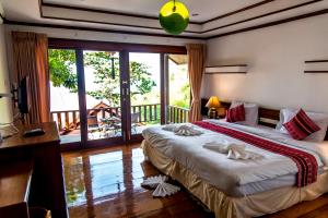 a hotel room with two beds and a balcony at Zama Resort Koh Phangan in Haad Chao Phao