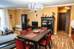 uma sala de estar com uma mesa de jantar com cadeiras vermelhas em Tenerra Lux Apartment em Varna City