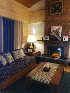 uma sala de estar com uma cama e uma lareira em HOMESTAY DE MARQS - STYLISH and SPACIOUS 3 BEDROOM VACATION HOME em Baguio