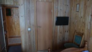 Habitación con puerta de madera y TV. en Salako svečių namai, en Salakas