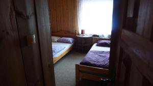 Habitación pequeña con 2 camas y ventana en Salako svečių namai, en Salakas