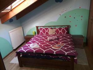 una camera con letto viola e piumone viola di Appartamento LUCE a Volpiano Altre 10 foto