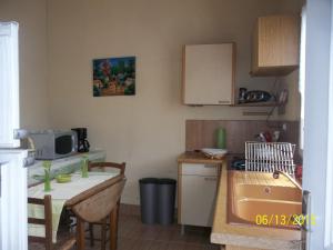 a small kitchen with a sink and a table with a tablektop at Alaguyauder le Studio in Châtillon-sur-Broué