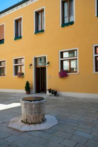 a yellow building with a tree stump in front of it at Hotel Al Malcanton in Venice