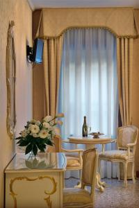 a living room with a table and chairs and a window at Hotel Al Malcanton in Venice