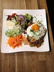 a plate of food with an egg and vegetables at Gasthof Zur Hohen Hunau in Schmallenberg