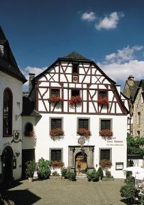 een wit gebouw met bloembakken op de ramen bij Hotel Haus Lipmann in Beilstein