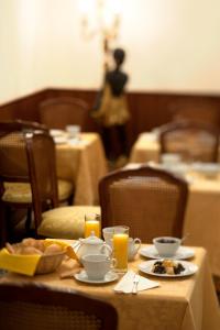 una mesa con platos de comida y vasos de zumo de naranja en Hotel Al Malcanton, en Venecia