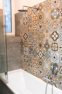 łazienka z prysznicem i ścianą wyłożoną kafelkami w obiekcie WONDER CRACOW w Krakowie
